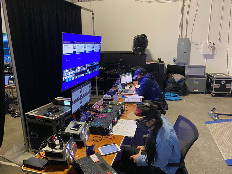 Event production team working behind the scenes during an event on their laptops with AV equipment