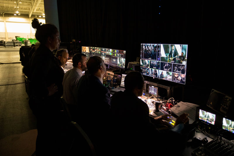Event production team overseeing a live event on a monitor while other monitors are used for technical adjustments
