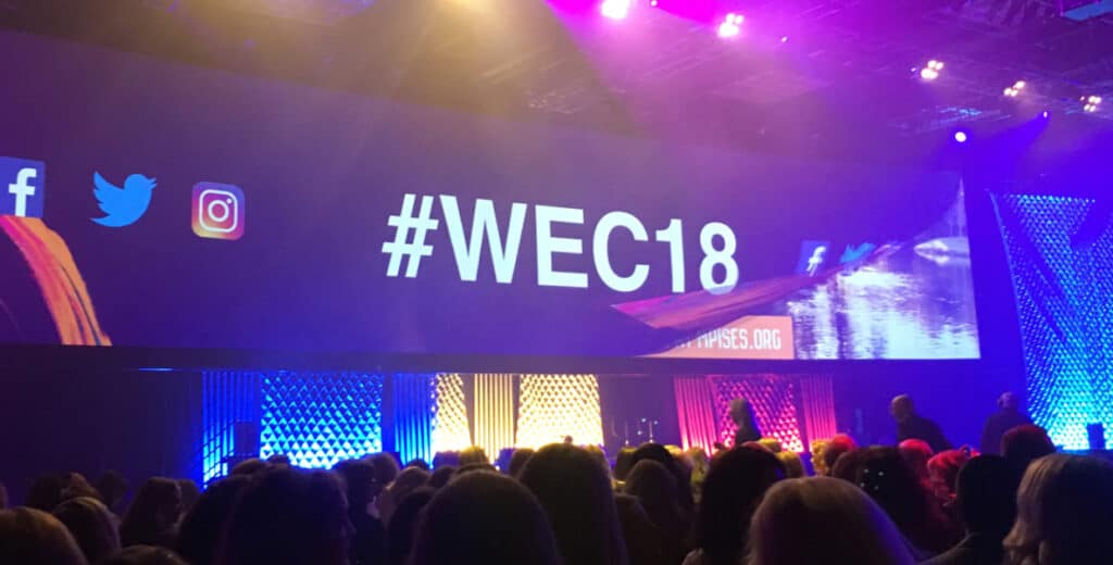 Event attendees looking at the projected screen onstage for #WEC18