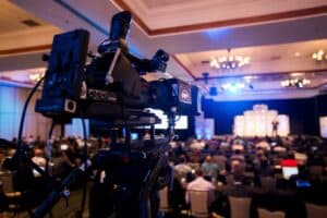 Video camera set up to record a live event from the back of a room