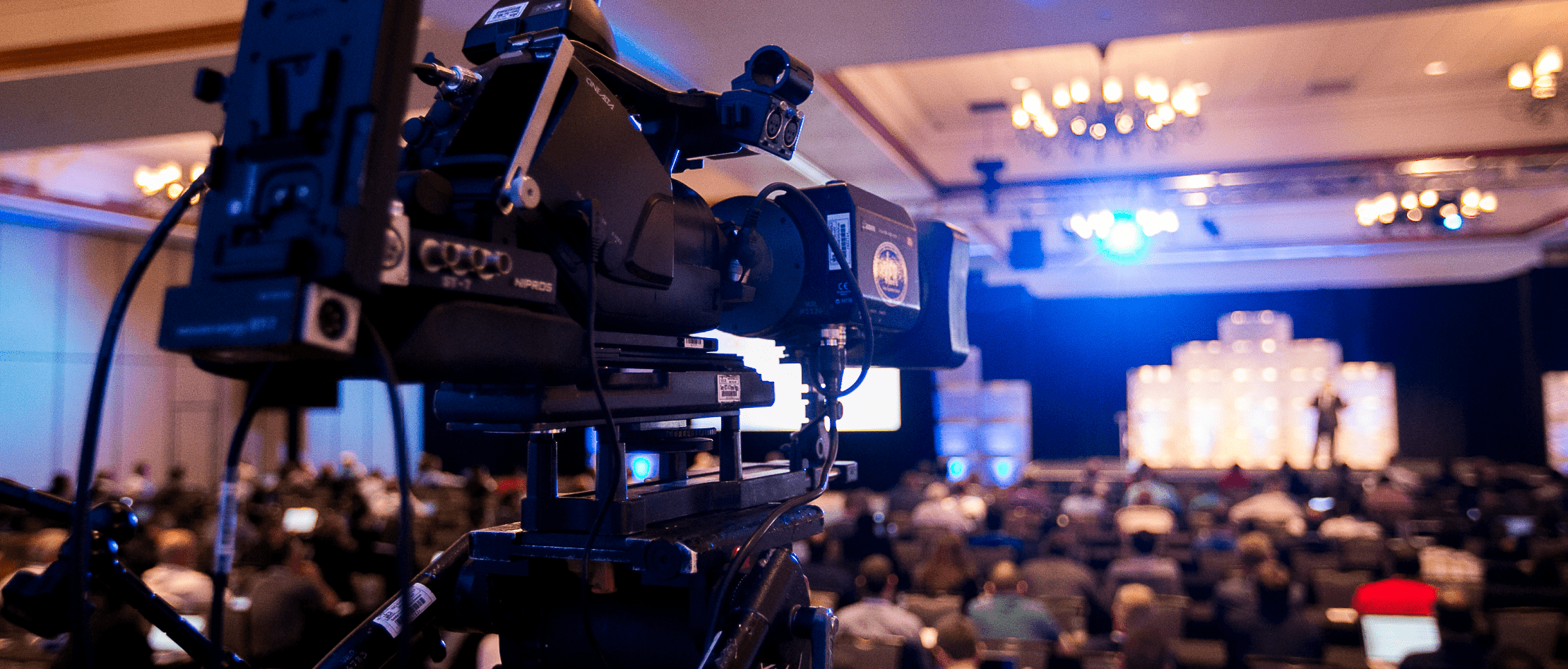 Video camera recording the live event from the back of a room