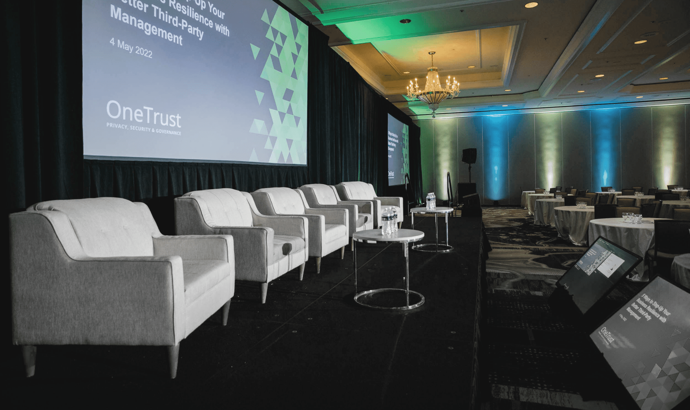 Event stage design with five gray arm chairs looking out towards the open room