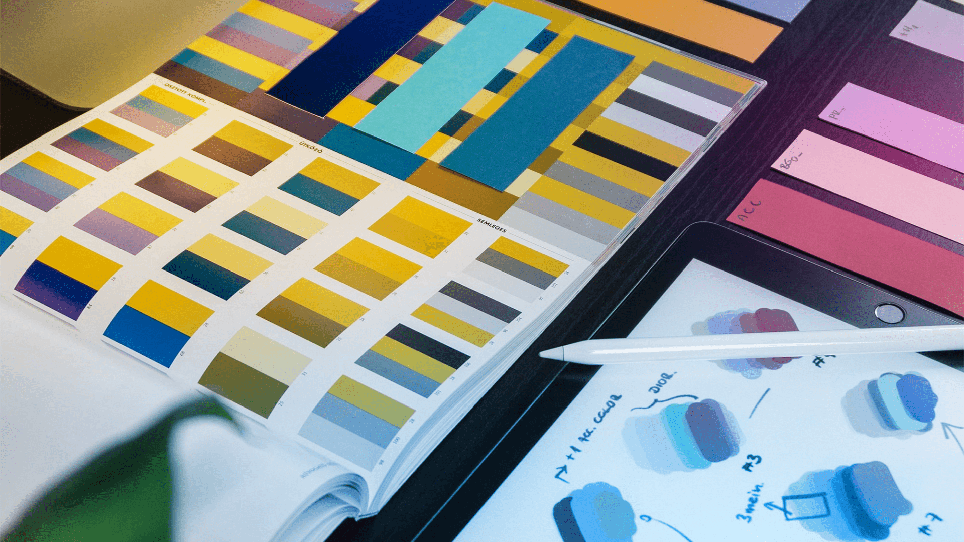 Printed color palette ideas for marketing banners laid on a table