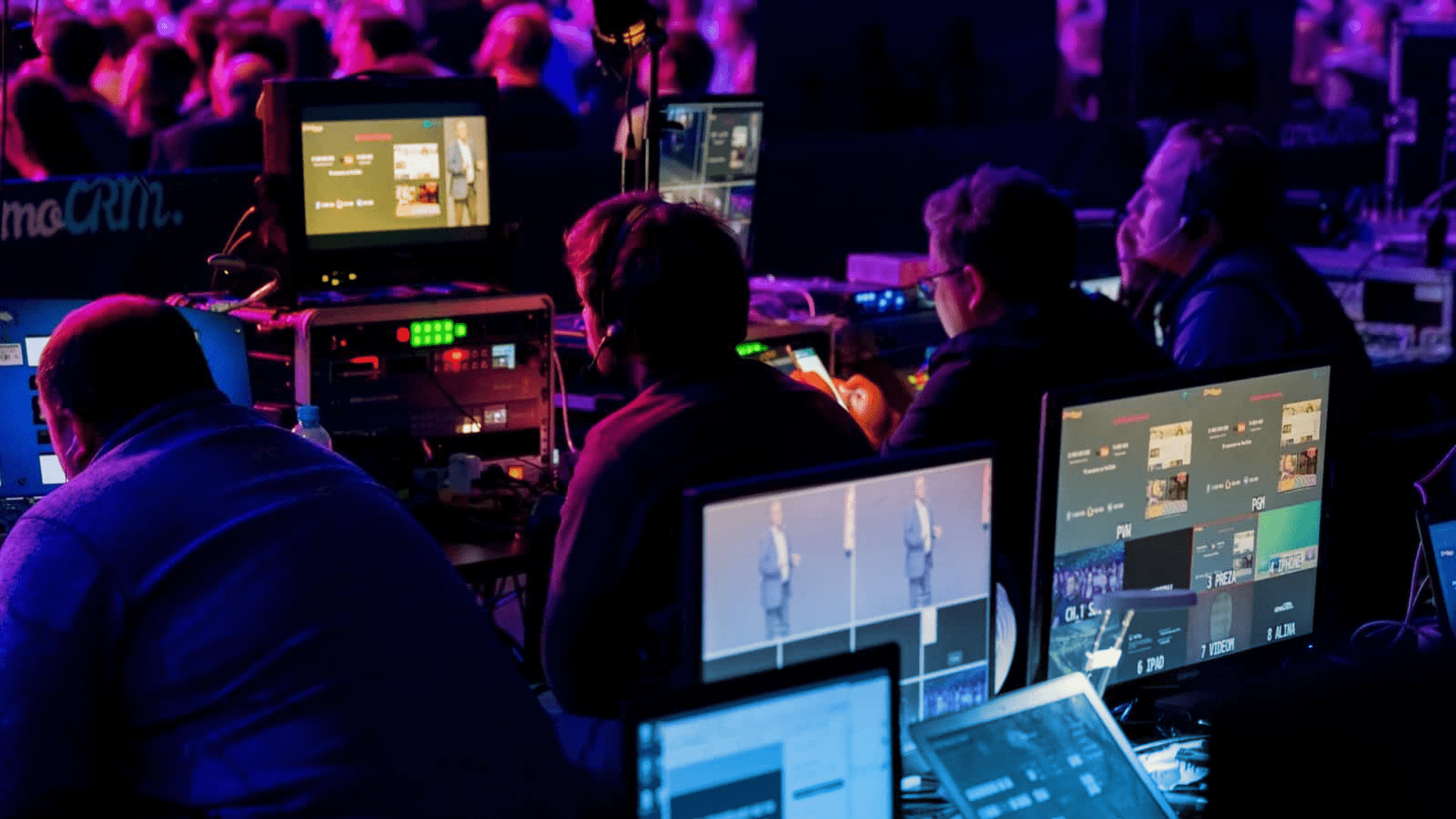 Event production team overseeing the technical aspects of a live event through their laptops and AV equipment