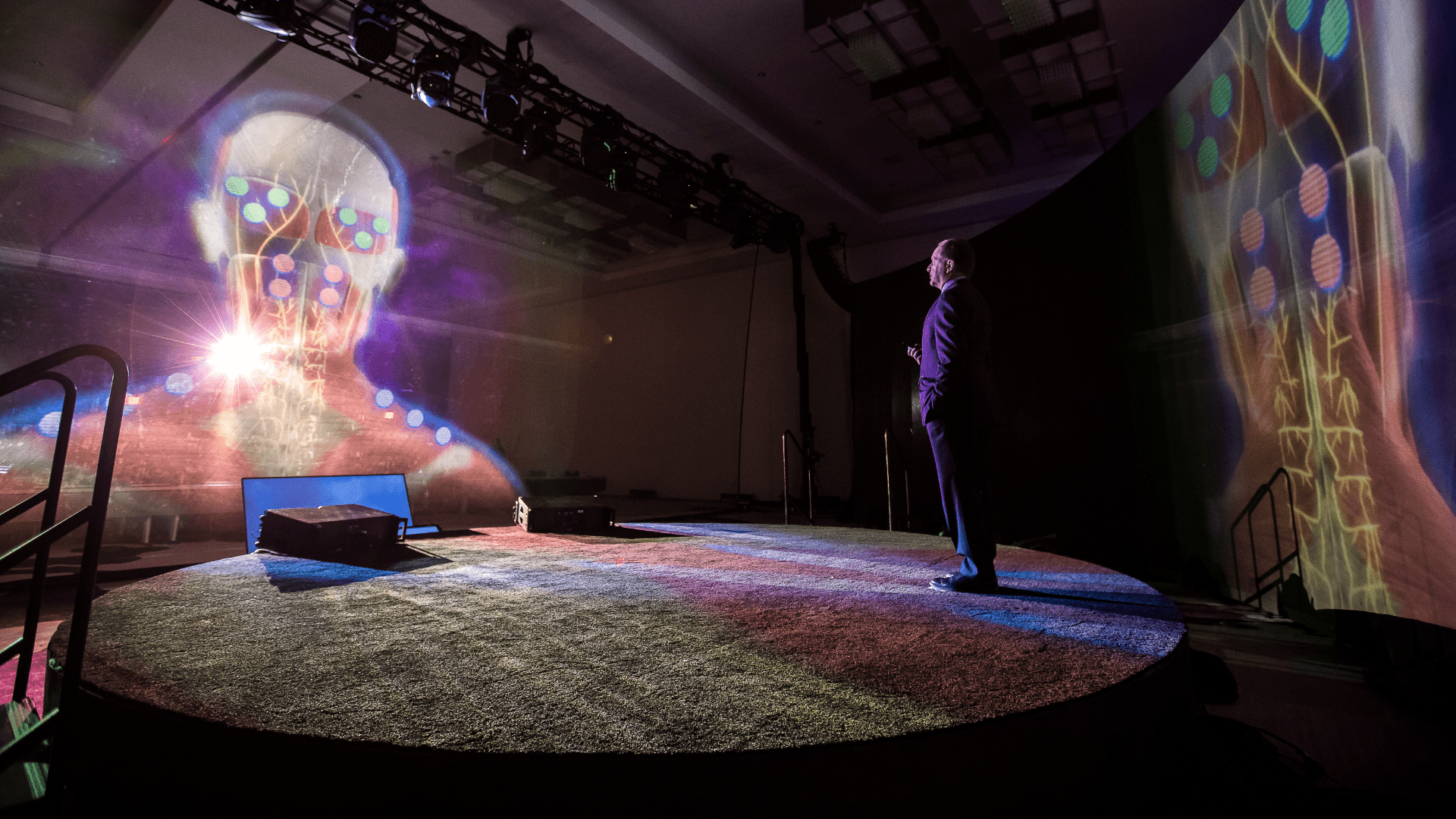 Man standing on stage with a hologram of a human brain for a live event for Allergan
