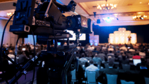 Video camera mounted at the back of a room to record a live event