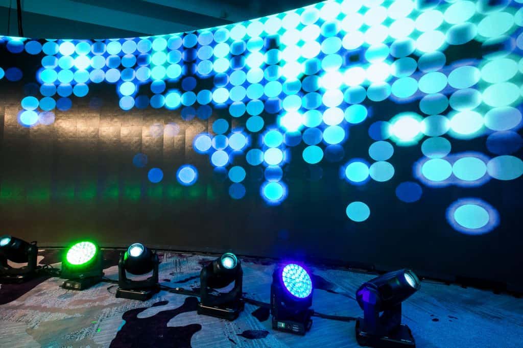 A large LED wall with moving lights in front